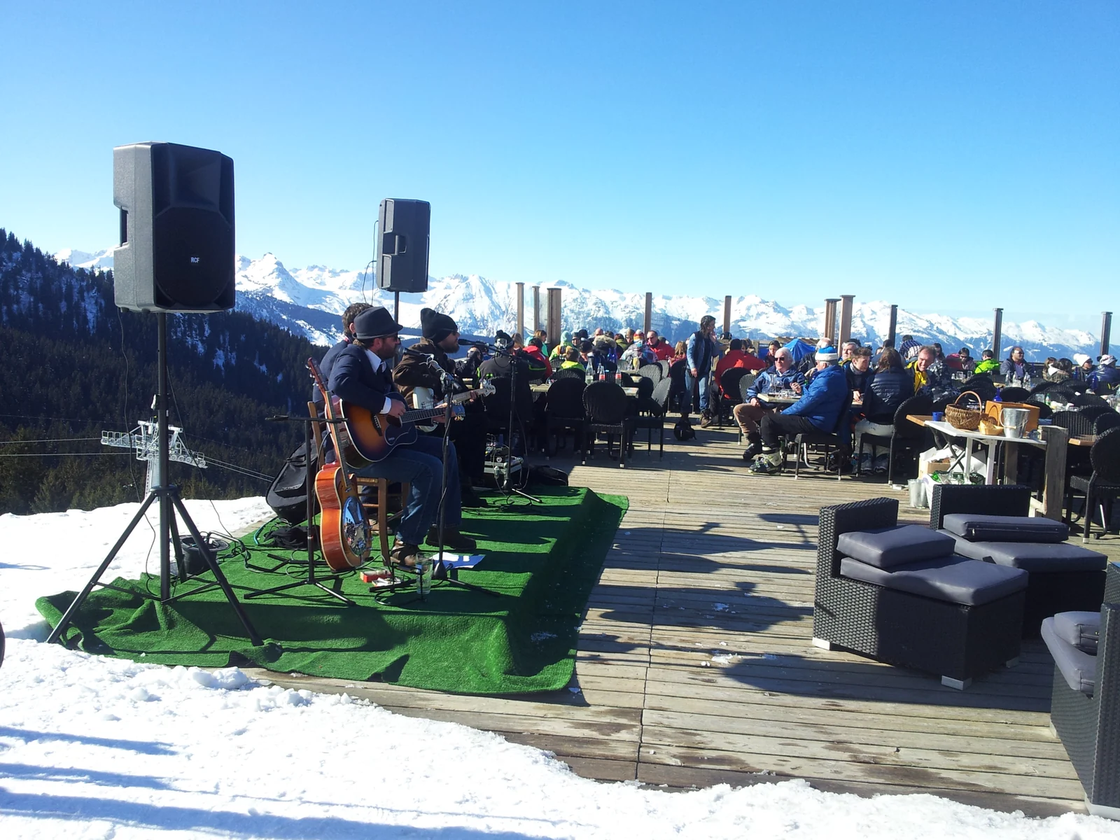 Concert acoustique et public sur une terrasse enneigée