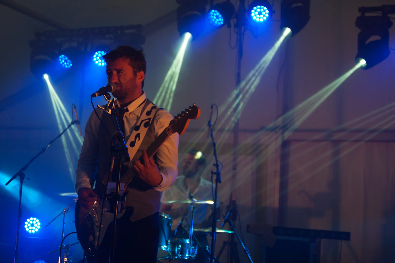 Yo à la guitare et à l’harmonica, avec Donnie derrière lui sous les projecteurs bleus
